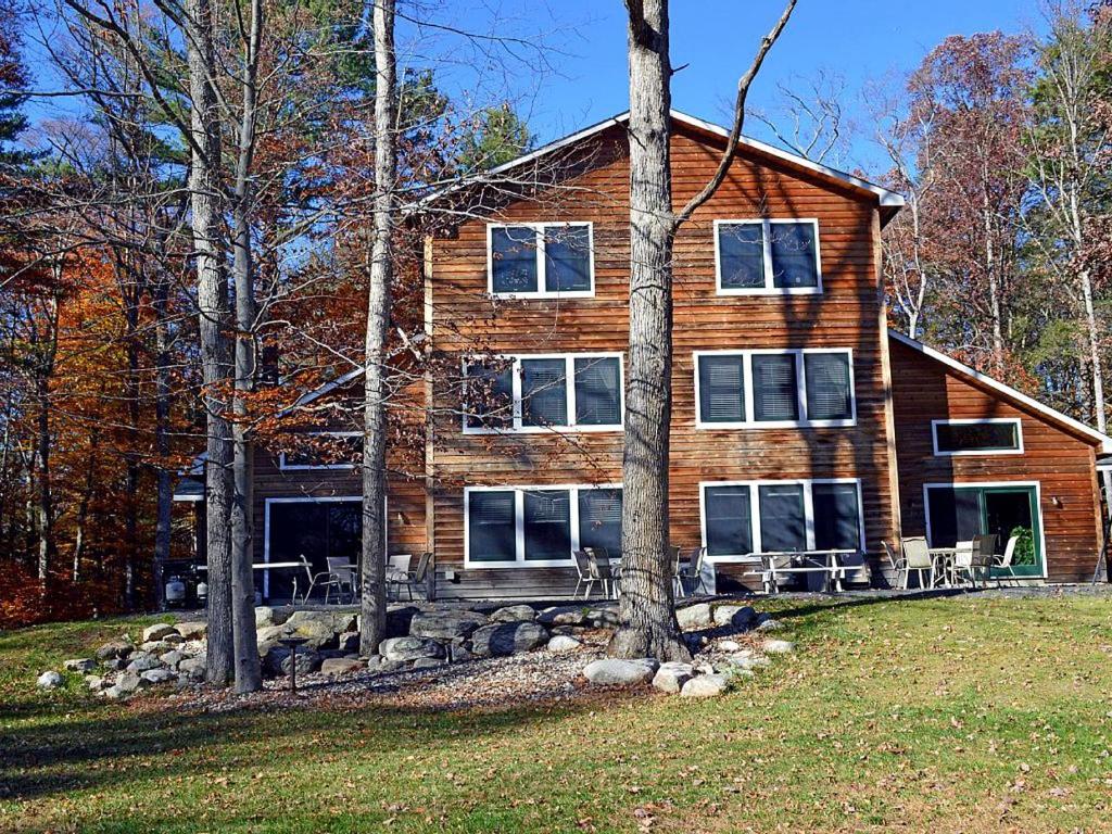 a large wooden house with trees in front of it at Enormous Family-Friendly Cabin Rental in Shawangunk Mountains, New York in Pine Bush