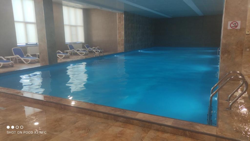 a large pool with blue water in a building at Alvina 2 apartment hotel Tsaghkadzor in Tsaghkadzor