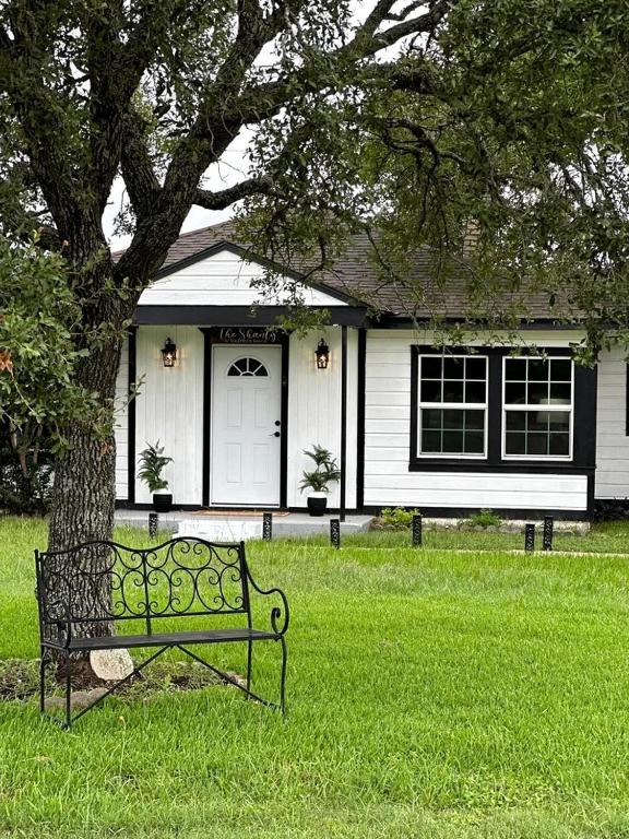 a bench sitting in the grass in front of a house at Spectacular Secluded Cottage in Round Top, Texas in Ledbetter