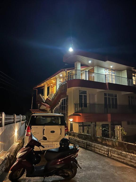 a motor scooter parked next to a house at night at Triolet Bed and Breakfast in Shillong