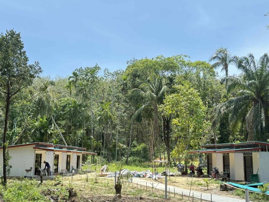 eine Häusergruppe vor einem Wald in der Unterkunft Kohmook Timberland Resort from Seaview in Ko Mook