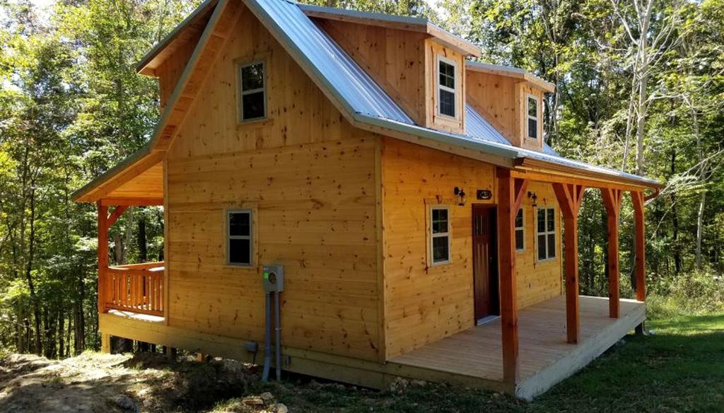 une cabane en bois avec un toit à la mansarde dans l'établissement Cozy Family-Friendly Cabin with Private Outdoor Jacuzzi near Huntington, West Virginia, à Genoa