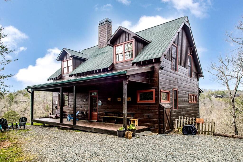 une grande maison en bois avec un toit dans l'établissement Modern and Cozy Cabin Rental Between Mountains and River in Northern Georgia, à Mineral Bluff