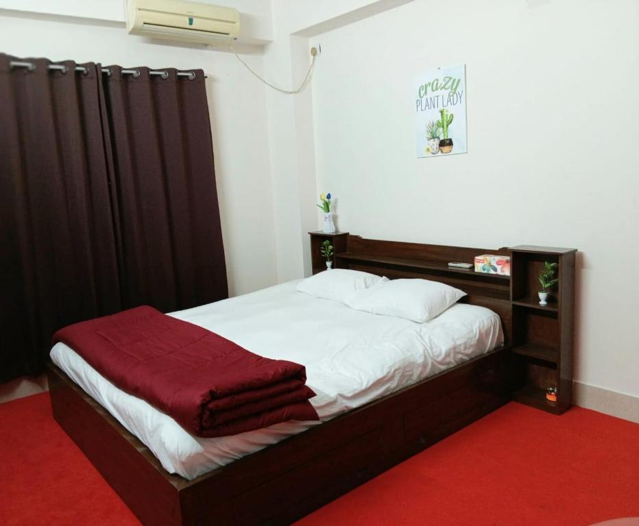 达卡The Blissful Heaven Dhaka的一间卧室配有一张铺有红地毯的床