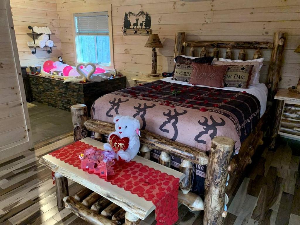 ein Schlafzimmer mit einem Bett und einem Tisch mit einem Teddybär in der Unterkunft Fantastic Secluded Cabin with Fire Pit and Hot-tub in Campbellsville, Kentucky in Campbellsville