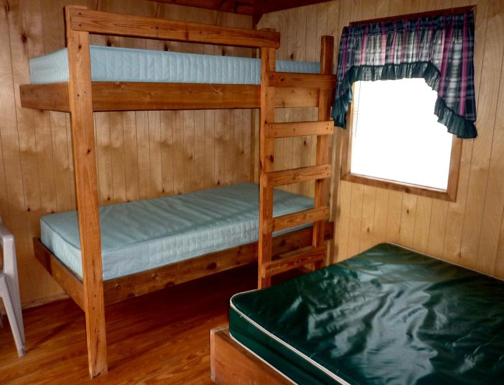 a bedroom with two bunk beds and a window at Charming Wooden Cabin with Fire Pit near West Yellowstone, Montana in Lakeview