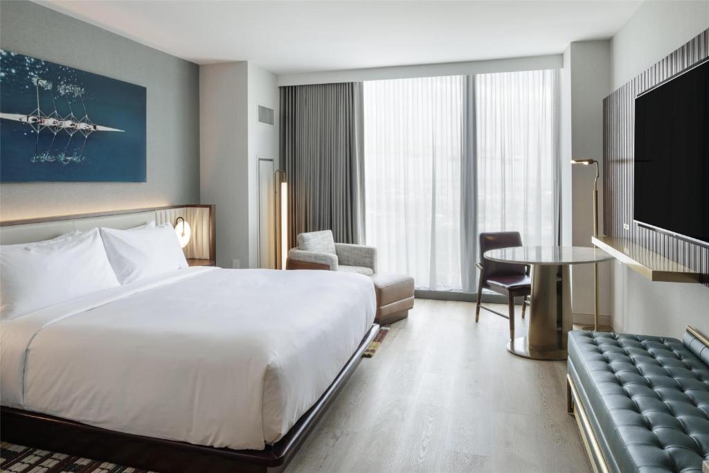 ein Hotelzimmer mit einem großen Bett und einem Tisch in der Unterkunft Hilton Arlington Rosslyn The Key in Arlington