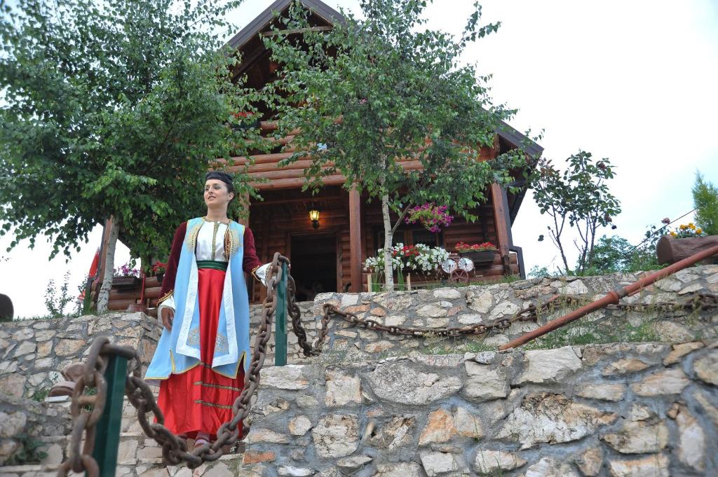 uma estátua de uma mulher em frente a uma casa em Holiday Home Zorić em Nikšić