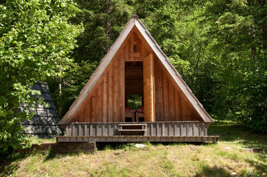 una pequeña cabaña de madera con techo triangular en Lovely Retreat for Adventurous Getaways in Slovenia, en Soča