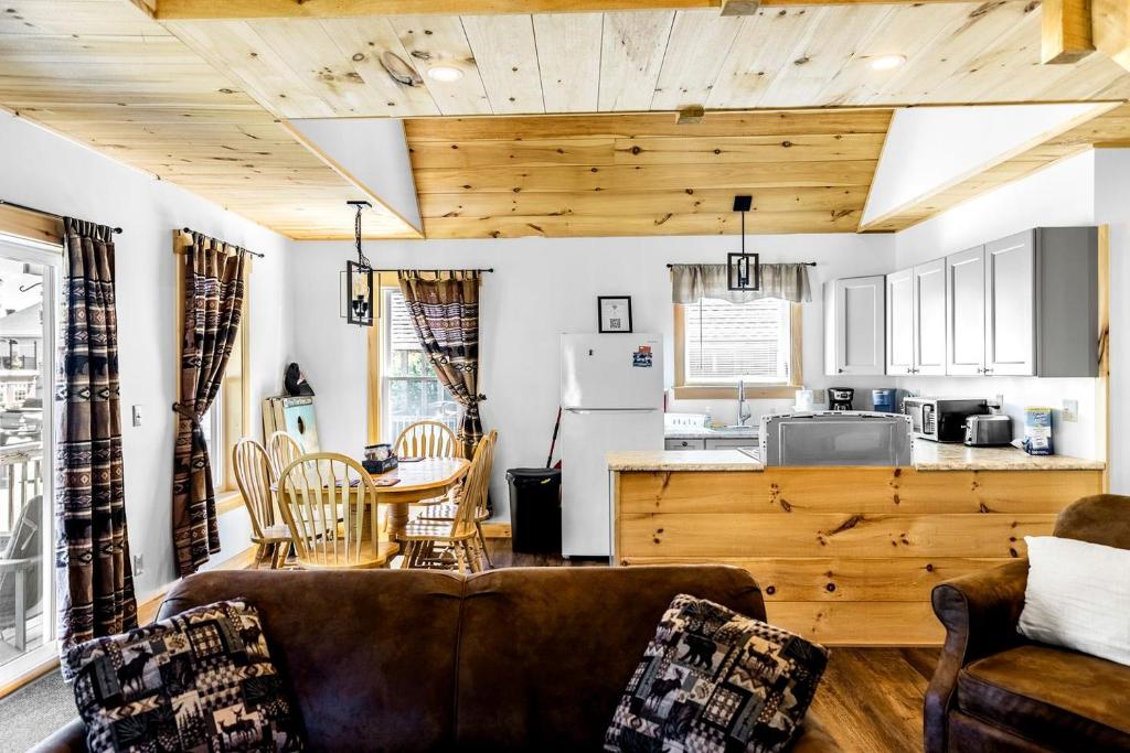 un salon avec un canapé et une table dans l'établissement Incredible Wooden Cabin with Fire Pit and Barbecue in Greenville, Maine, à Greenville