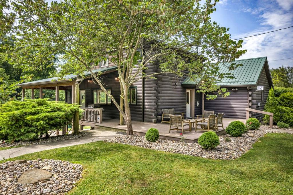 a log cabin with a table and chairs in a yard at Exquisite Cabin with Amazing Interior and Exterior in Sarahsville, Ohio in Senecaville