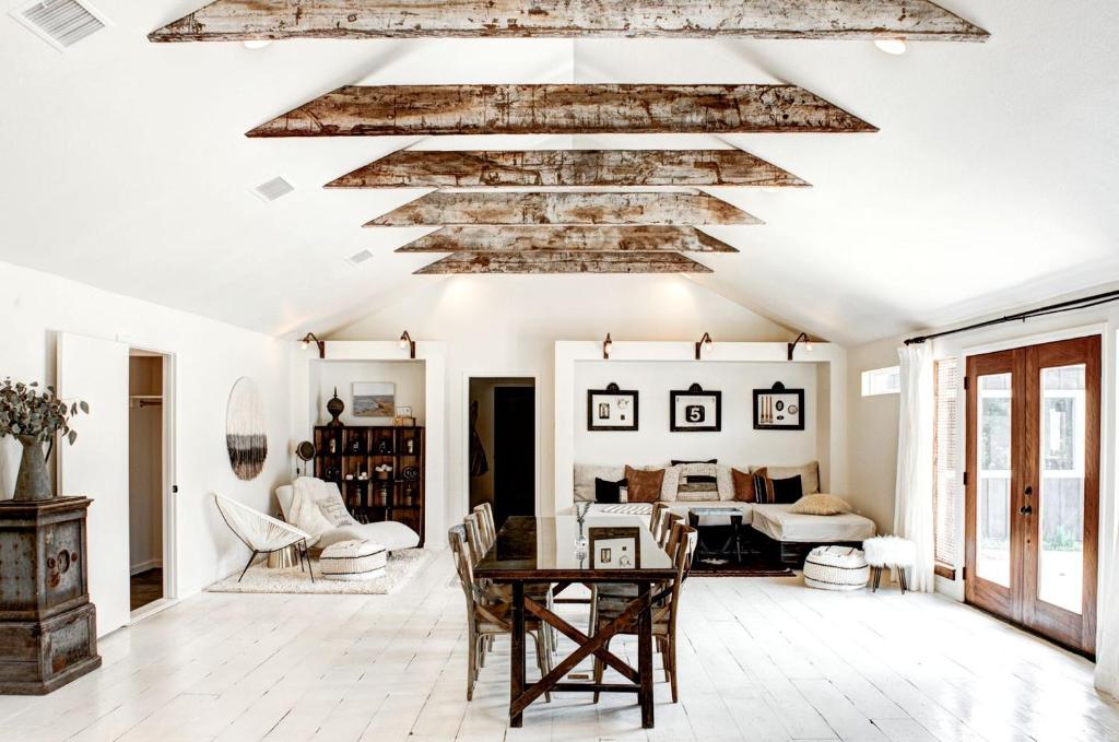 a living room with a wooden ceiling and a table at Modern Luxury Rental with Bohemian Decor near Antique Show in Round Top, Texas in Round Top