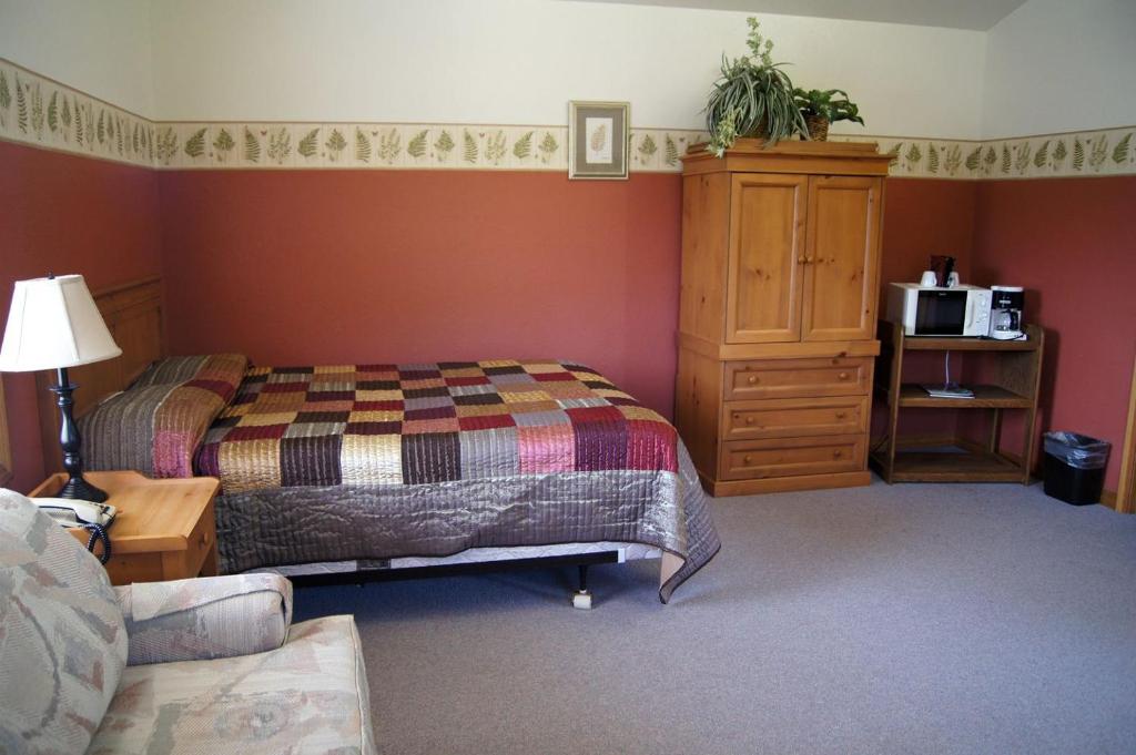 a bedroom with a bed and a dresser with a microwave at Idyllic Camping Cabin on 2500-Acre Ranch in the Umpqua River Valley, Oregon in Elkton
