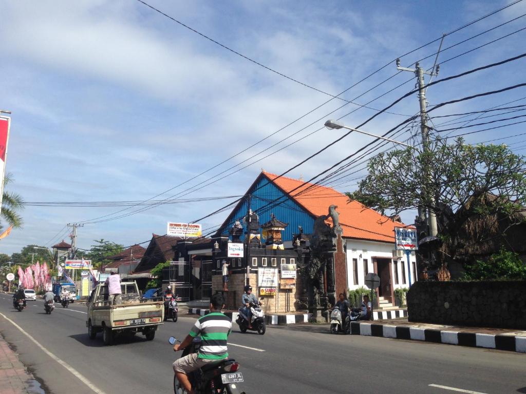 a group of people riding motorcycles down a city street at Hotel Dupa in Lovina