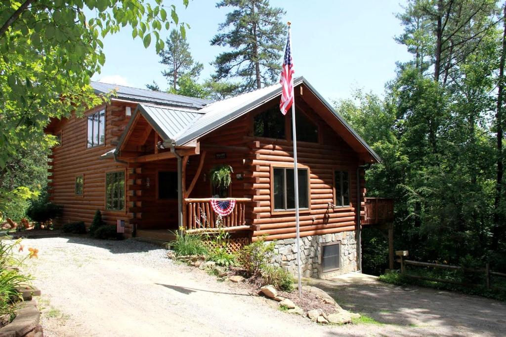 une cabane en rondins dotée d'un drapeau américain. dans l'établissement Deluxe Log Cabin with a Hot Tub in the Smoky Mountains of North Carolina, à Crabtree