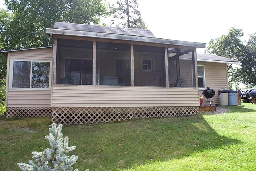 a small house with a screened porch in a yard at Lakefront Cabin Rental with a Screened-In Porch near Pequot Lakes, Minnesota in Pine River