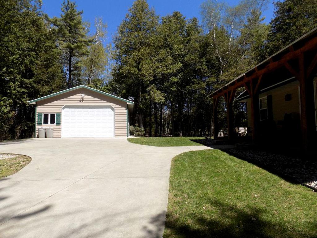 a garage with a white garage door next to a house at Spacious Vacation Rental with a Stunning Stone Gas Fireplace in Fish Creek, Wisconsin in Fish Creek