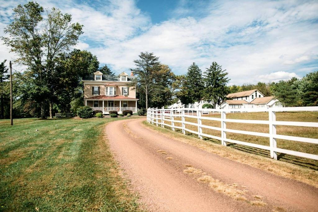 a dirt road in front of a house with a fence at Charming Accommodation for a Weekend Getaway in Buckingham Township, Pennsylvania in Buckingham