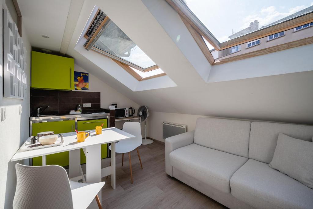 a living room with a couch and a table at Studio sous les toits Annecy Centre-Ville in Annecy