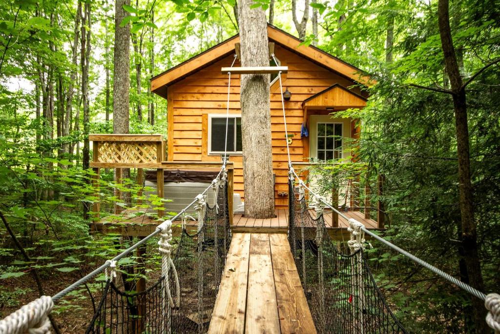 a wooden cabin in the woods with a cross on it at Breathtaking Tree House Rental near Charleston, West Virginia in Hico