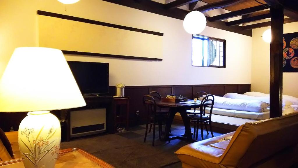 un soggiorno con letto, tavolo e sedie di Rickshaw inn a Takayama