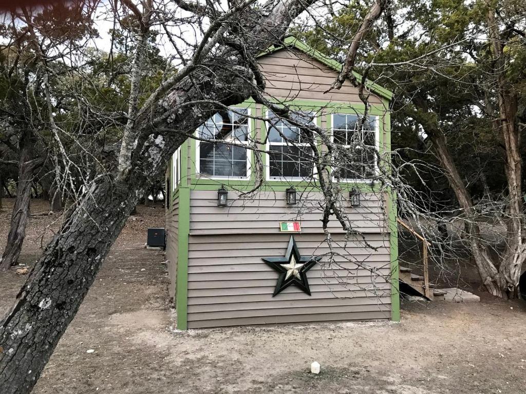a house with a star painted on the side of it at Cozy Cabin for Glamping on a Texas Horse Ranch, Perfect for a Equine Escape in Kreutzberg