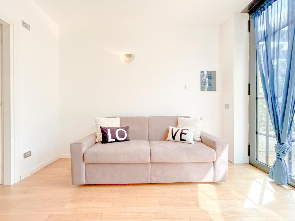 a couch in a living room with two pillows on it at 35 - Casa a due passi Dal mare Terrazza - Wifi - AC in Savona