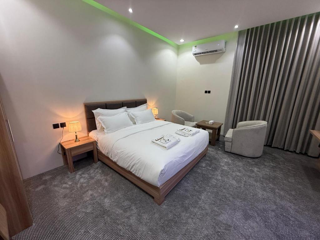 a bedroom with a bed with a green light on it at شقق دفادف المخدومة in Hail