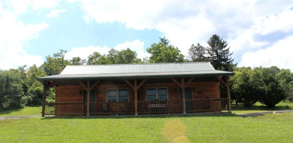 a log cabin with a metal roof on a green field at Luxury Accommodation for Fun Places to Go in Maryland in Flintstone