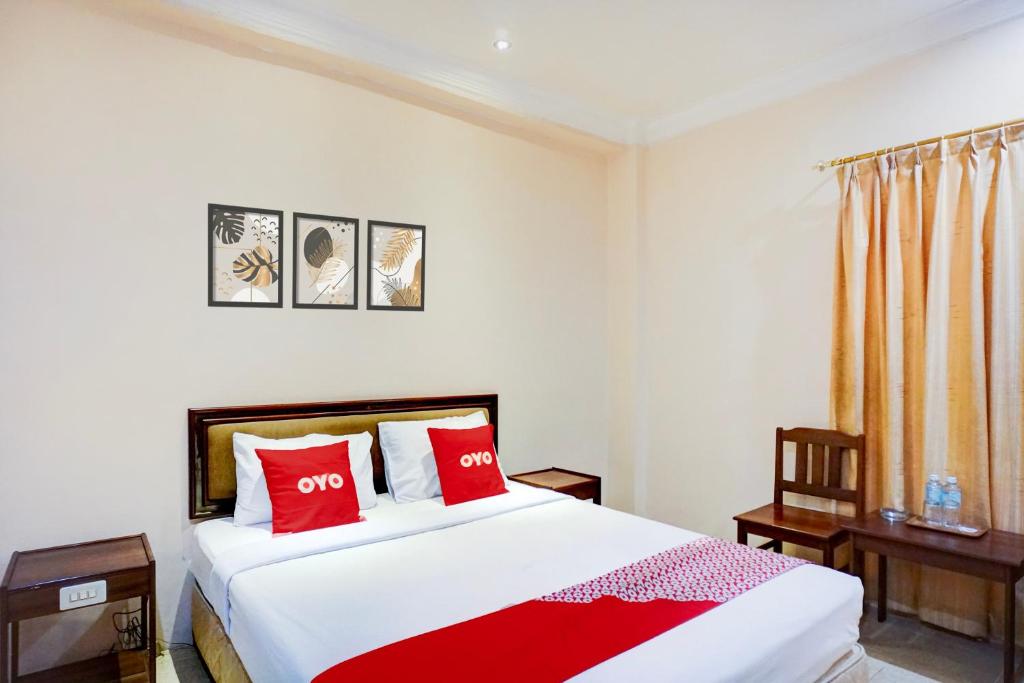 a bedroom with a large bed with red pillows at OYO 94799 Siwah Hotel in Banda Aceh