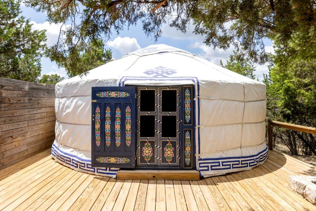 a yurt with a door on a wooden deck at Secluded Romantic Yurt with Hot Tub in Wimberley, Texas in Cloptins Crossing