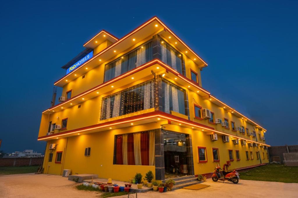 a large yellow building with lights on it at FabHotel Shree Venkatesh Nileyam in Ayodhya