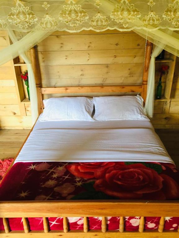 a bed in a wooden room with at One love archive in Chabahinga