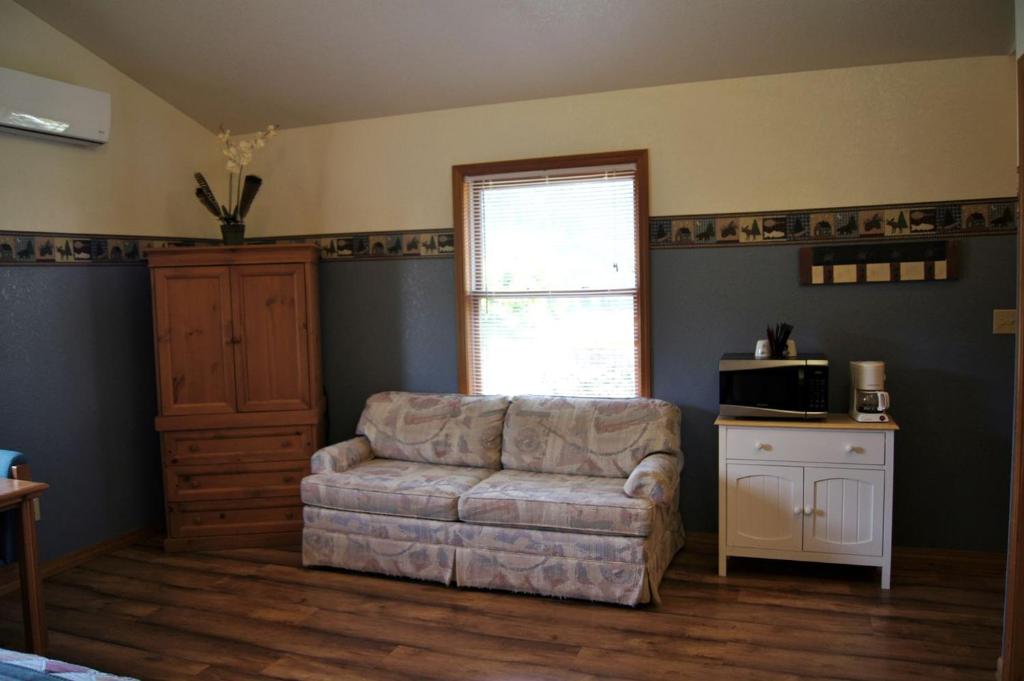 a living room with a couch and a microwave at Charming Cabin by the Umpqua River Perfect for an Outdoor Getaway in Oregon in Elkton
