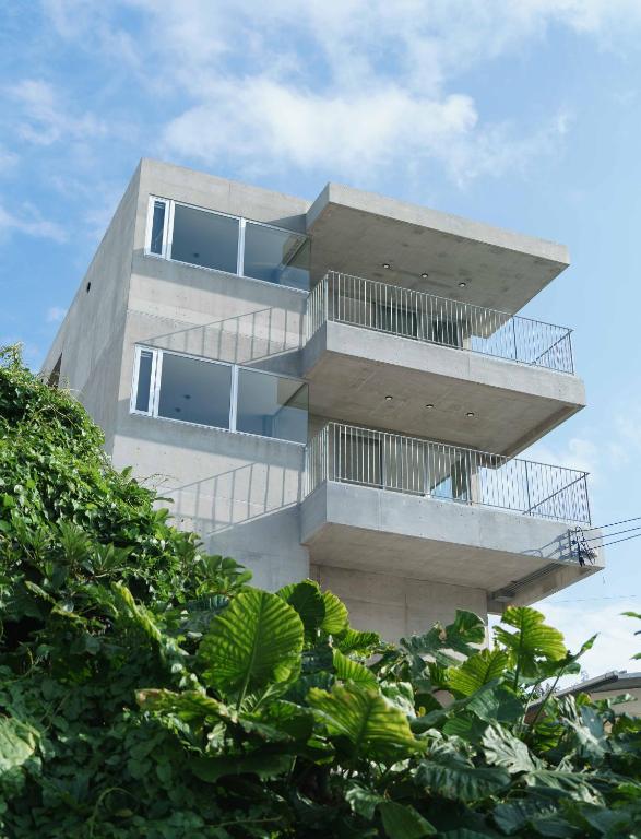 a building with balconies and trees in front of it at Emerald Ocean Villa in Onna