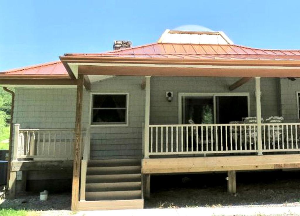 une petite maison avec un porche et une terrasse dans l'établissement Peaceful Weekend Getaway Accommodation near Youghiogheny River Lake, Pennsylvania, à Confluence