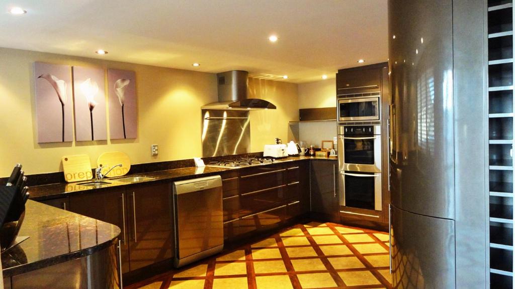 a kitchen with stainless steel appliances and brown cabinets at Pukaki Holiday Apartments in Rotorua