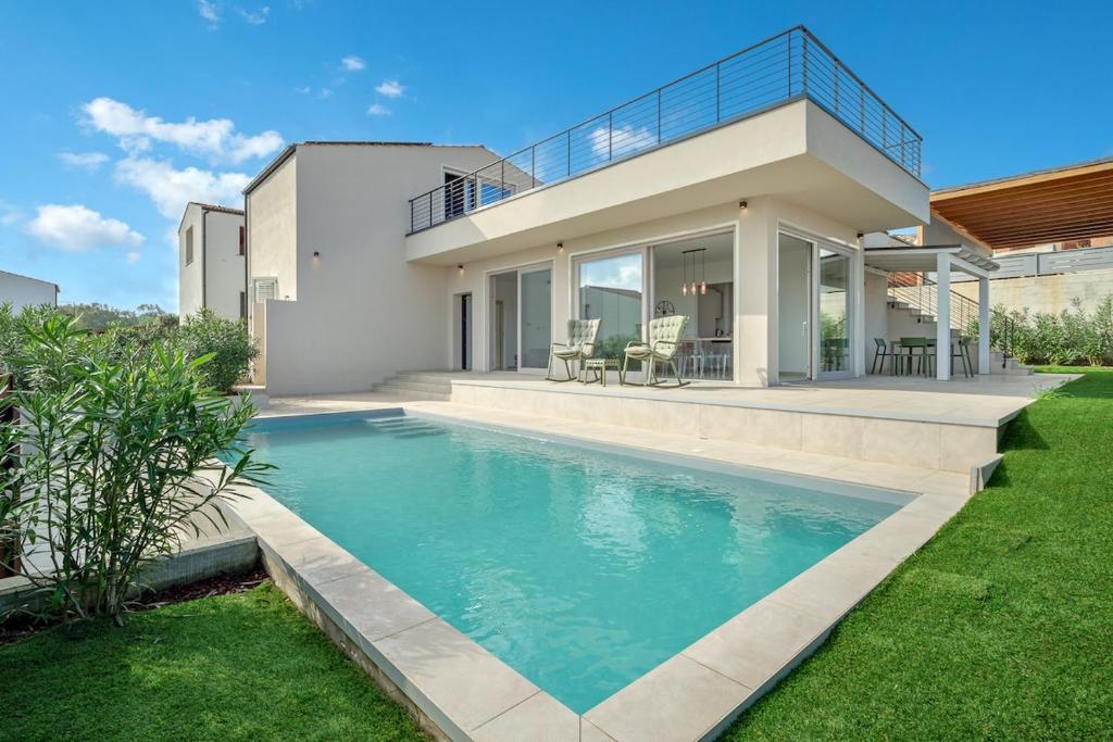 ポルト・ポッツォにあるVilla Luce in Sardegnaの家の前にプールがある家