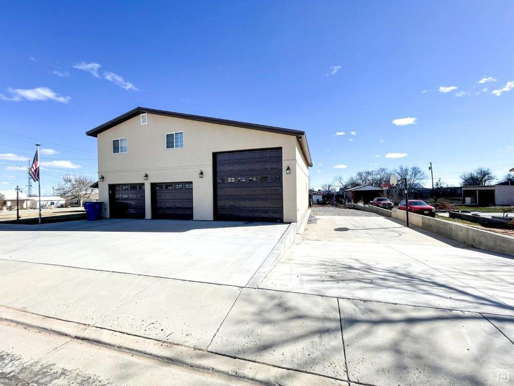 a large white building with two garage doors at Incredible Cottage Close to Fantastic Hiking Trails Blanding, Utah in Blanding