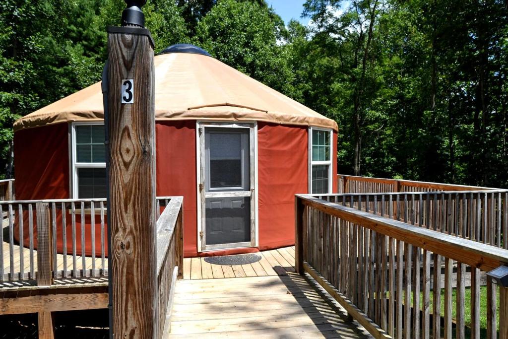 a yurt on a wooden deck with a pole at Intimate Yurt Rental Ideal for Romantic Glamping in Virginia in Rich Creek