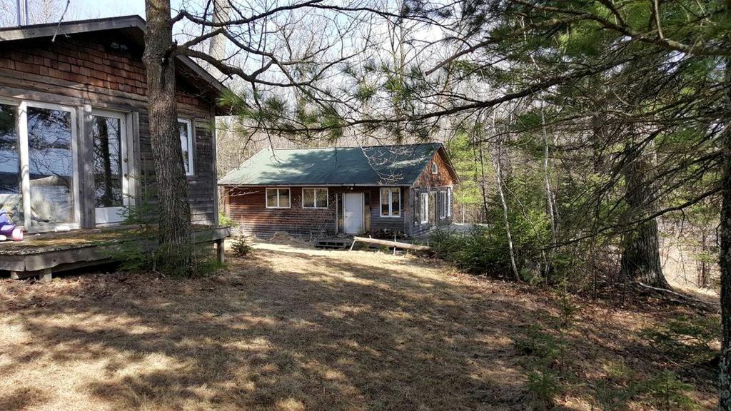 a small brick house with a porch in a yard at Idyllic Lake Cabin for a Camping Getaway in Cross Wing County, Minnesota in Emily