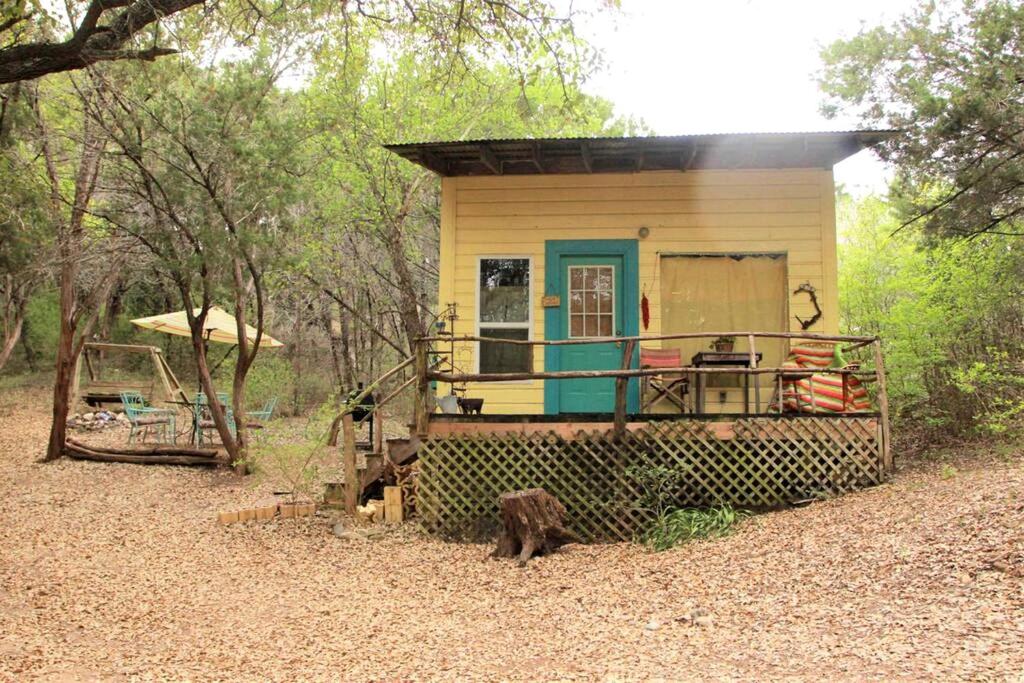 a small house in the middle of a forest at Rustic Cabin Rental Perfect for Families in Texas Hill County in Marble Falls