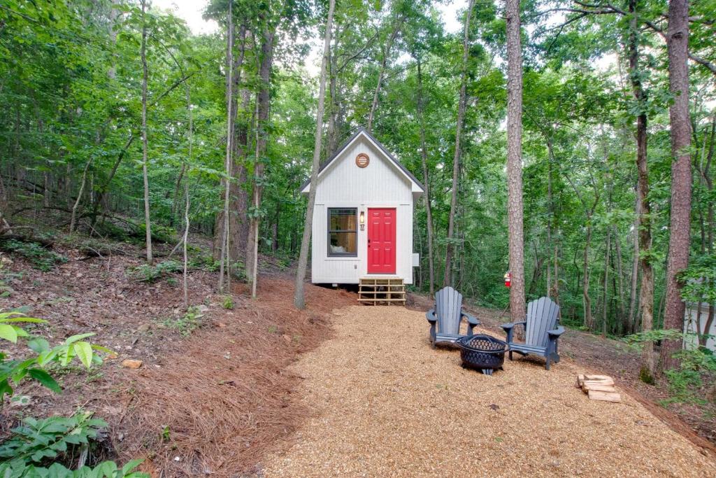 a tiny house in the woods with a red door at Picturesque Tiny Cabin Surrounded by Nature in Alabama in Grant