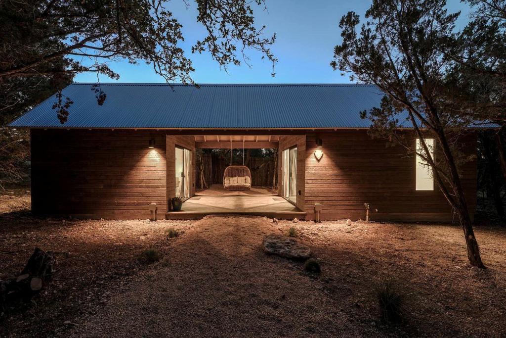 ドリッピング・スプリングスにあるClassically Southern Texas Hill Country Cabins for Weekend Getaways near Austinの青い屋根と窓のある小さな家