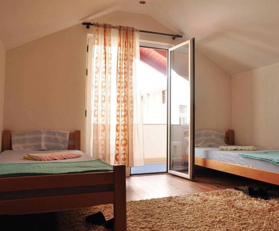 een slaapkamer met 2 bedden en een grote spiegel bij Guest House Mirza in Mostar