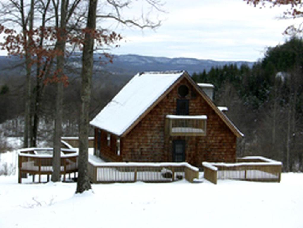 a building with a snow covered roof in the snow at Cabin Rental with Hot Tub in the New River Gorge Region of West Virginia in Glen Jean