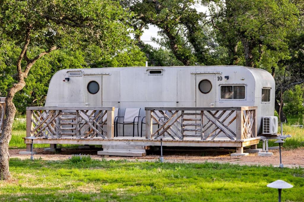 a trailer parked in a field next to a tree at Vintage Camper Amazingly Equipped Great for a Unique Getaway in Texas in Spicewood