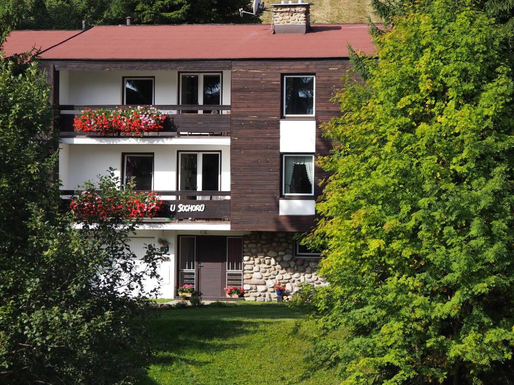 an apartment building with flower boxes on the windows at Penzion U Sochoru in Pec pod Sněžkou