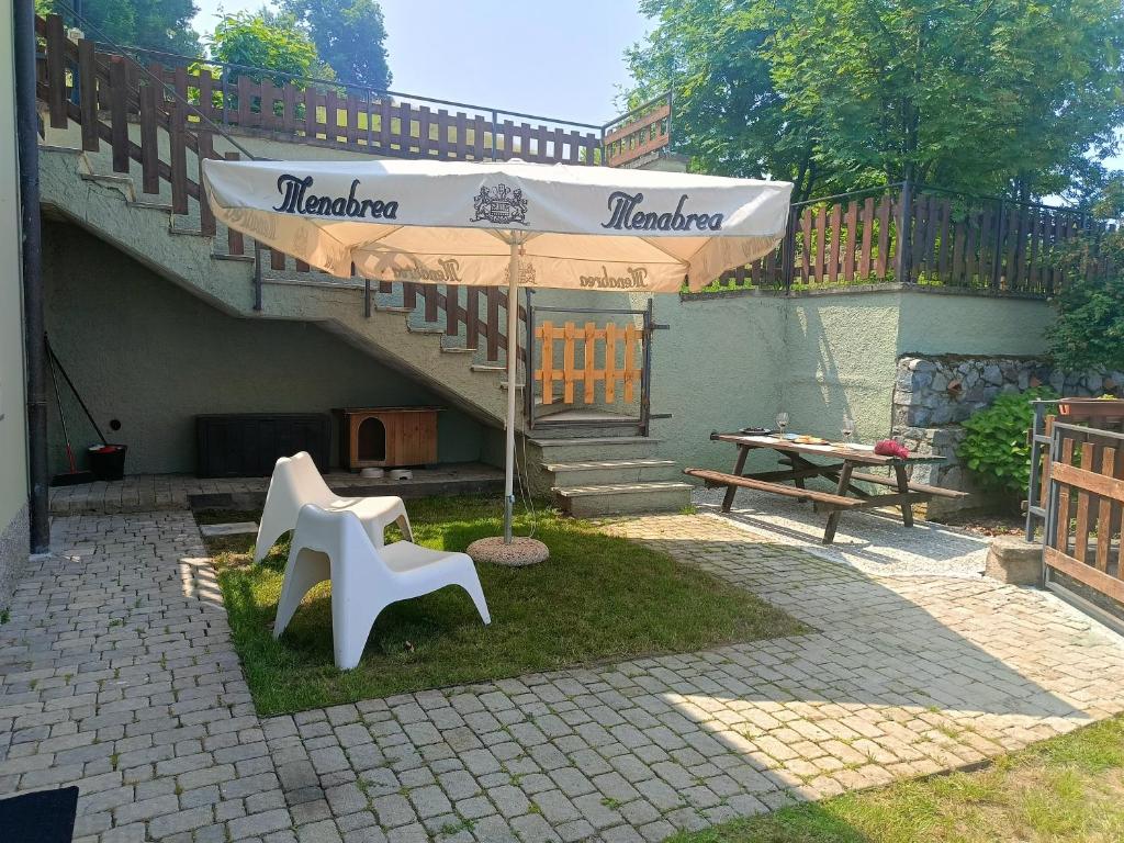 a patio with an umbrella and a table and bench at Villa Bruna by Holiday World in Pisogne