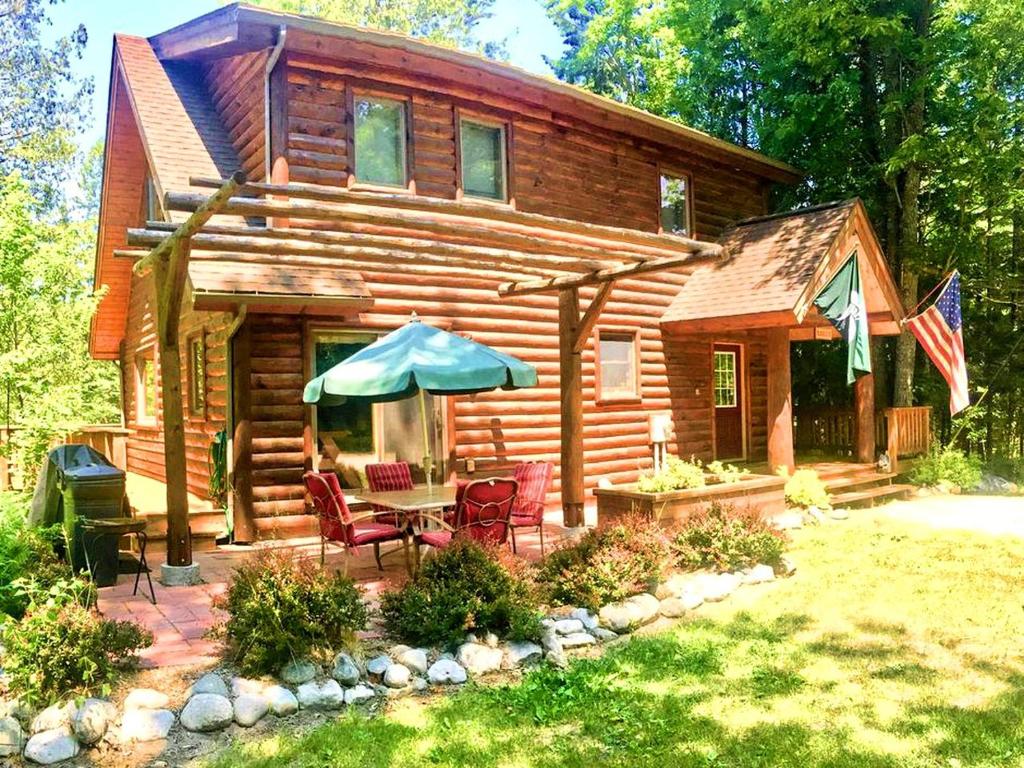 Κήπος έξω από το Cozy and Spacious Log Cabin Rental near Burt Lake State Park in Michigan